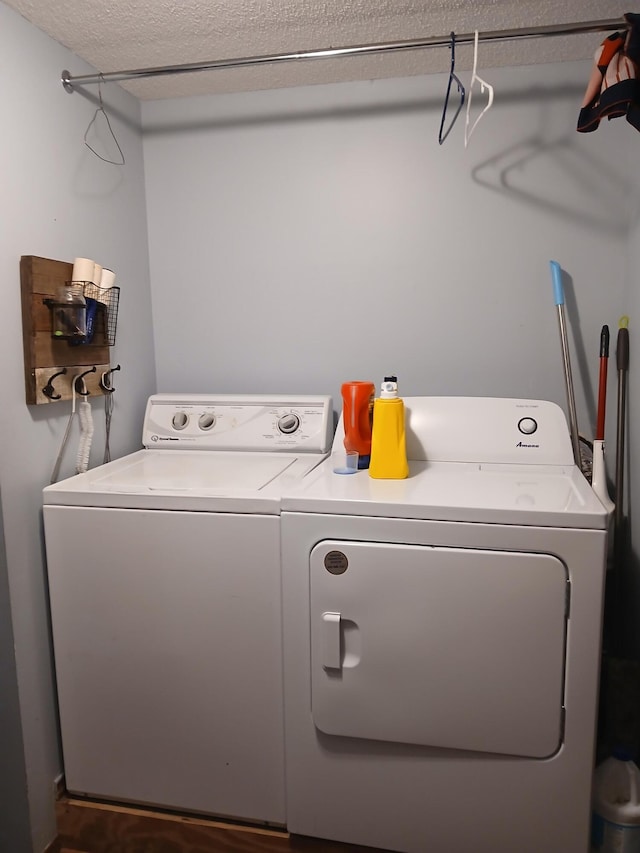 laundry area featuring washing machine and dryer and a textured ceiling