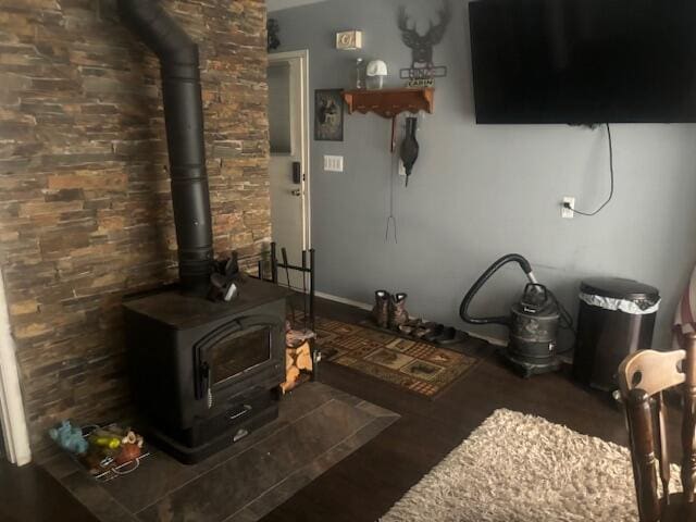 living room featuring a wood stove and dark wood-type flooring