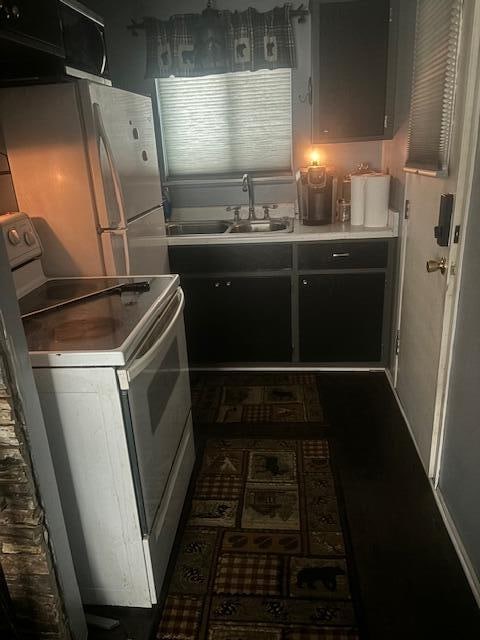 kitchen featuring range, sink, and stainless steel fridge