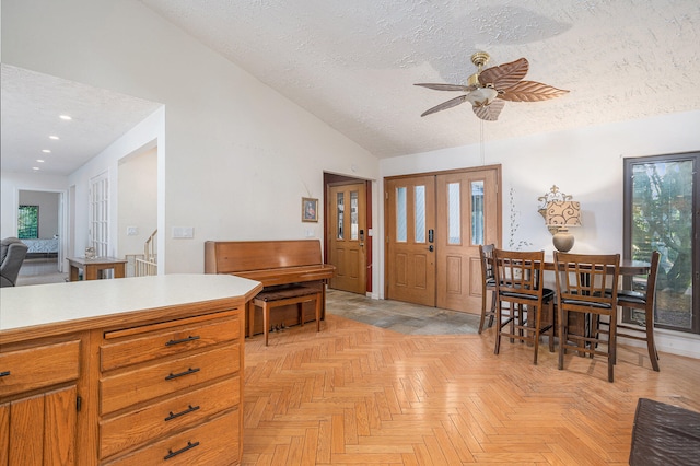 kitchen featuring ceiling fan, a textured ceiling, lofted ceiling, and light parquet floors