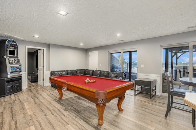 playroom with billiards, a textured ceiling, and light hardwood / wood-style floors