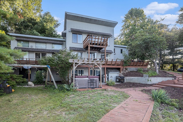 back of property with a pergola, a deck, and a yard