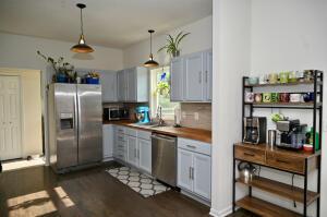 kitchen featuring tasteful backsplash, dark wood-type flooring, pendant lighting, and stainless steel appliances