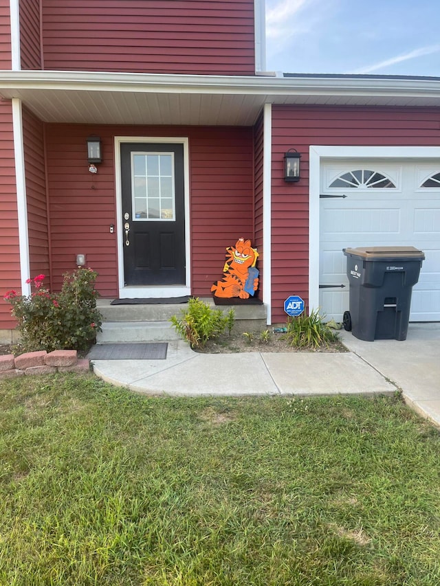 doorway to property featuring a yard and a garage