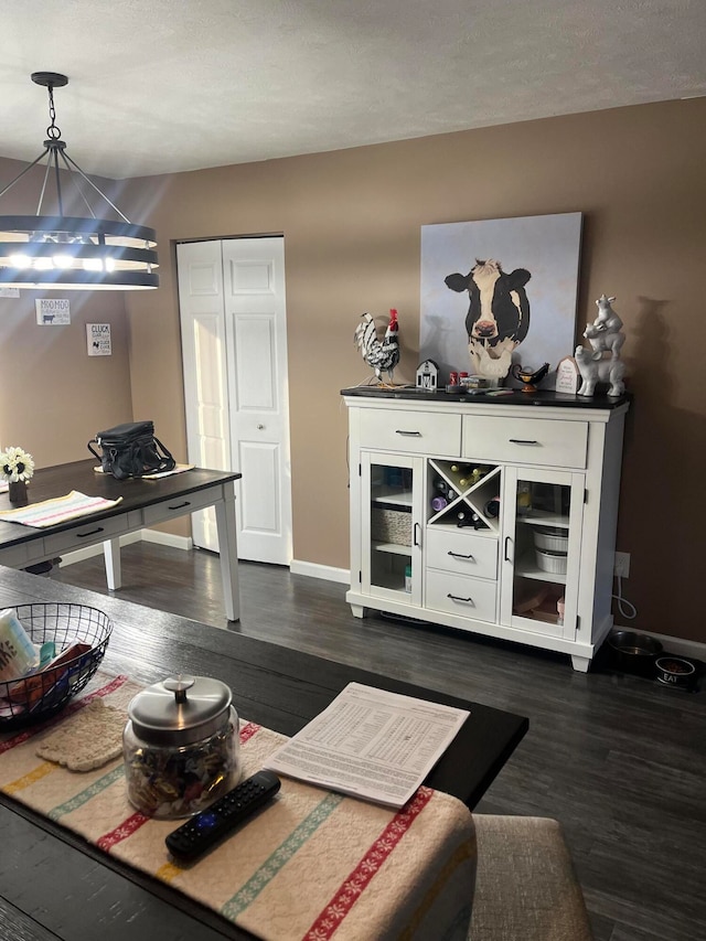 dining area with a textured ceiling and dark hardwood / wood-style floors