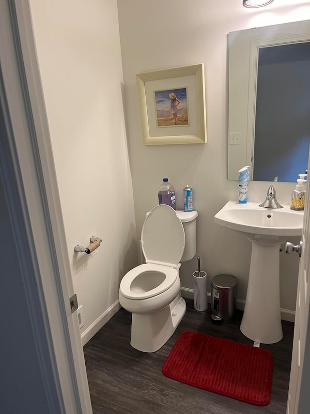 bathroom featuring wood-type flooring and toilet