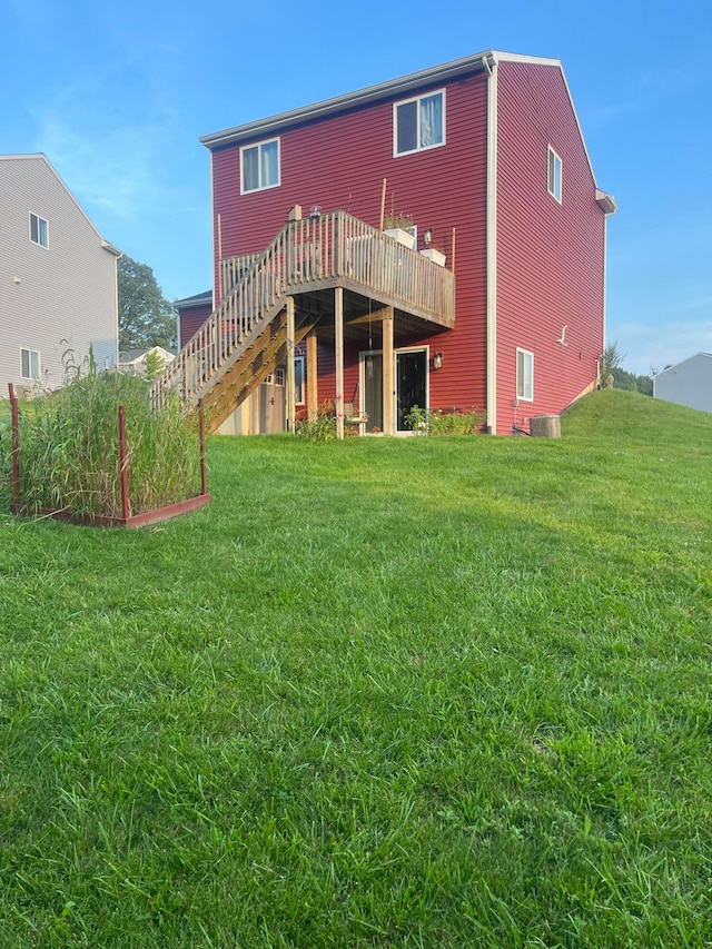 rear view of house with a lawn and a deck