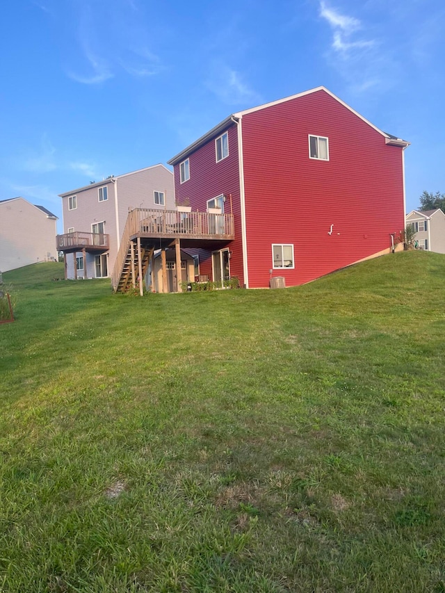 rear view of property with a deck and a yard