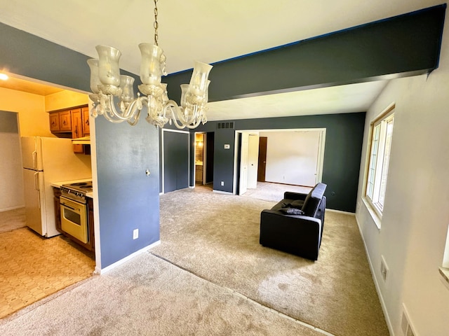 interior space with light colored carpet, an inviting chandelier, stainless steel stove, and white refrigerator