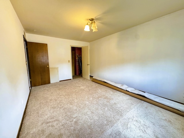 unfurnished bedroom with light colored carpet and a closet