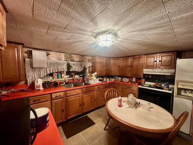 kitchen with electric range, brown cabinets, a sink, under cabinet range hood, and white refrigerator with ice dispenser