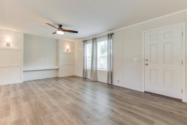 unfurnished room with ceiling fan, built in shelves, and wood-type flooring