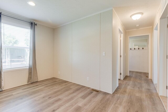 spare room featuring light hardwood / wood-style flooring and ornamental molding