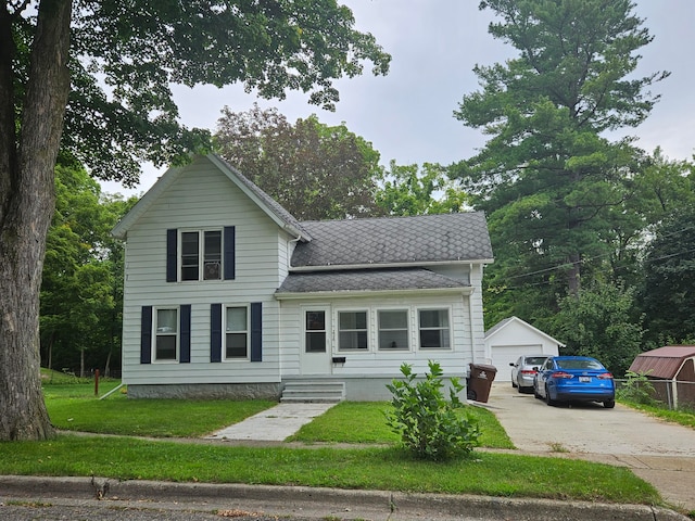 view of front of property featuring an outbuilding, a garage, and a front lawn