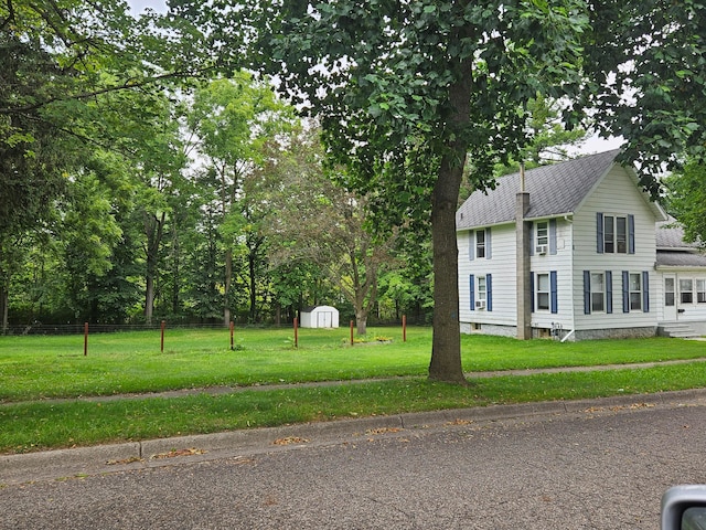 view of property exterior featuring a storage unit and a yard