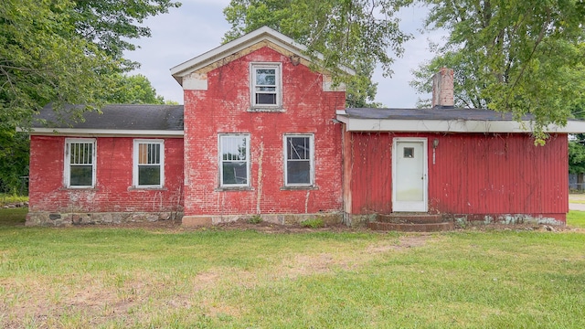 back of property featuring a lawn