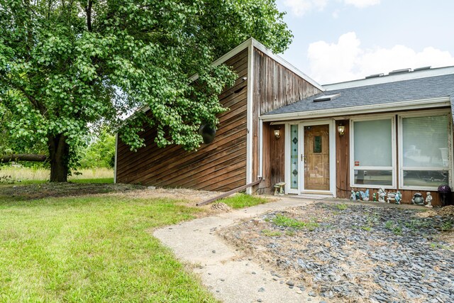 doorway to property featuring a lawn