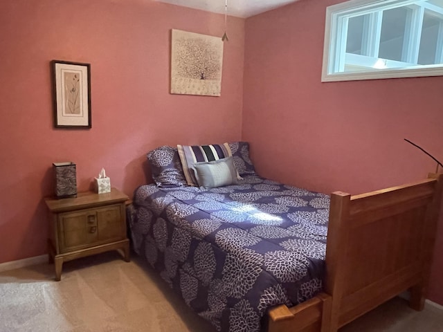 bedroom with baseboards and light carpet