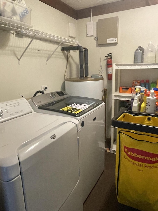 clothes washing area featuring washing machine and clothes dryer, laundry area, and water heater