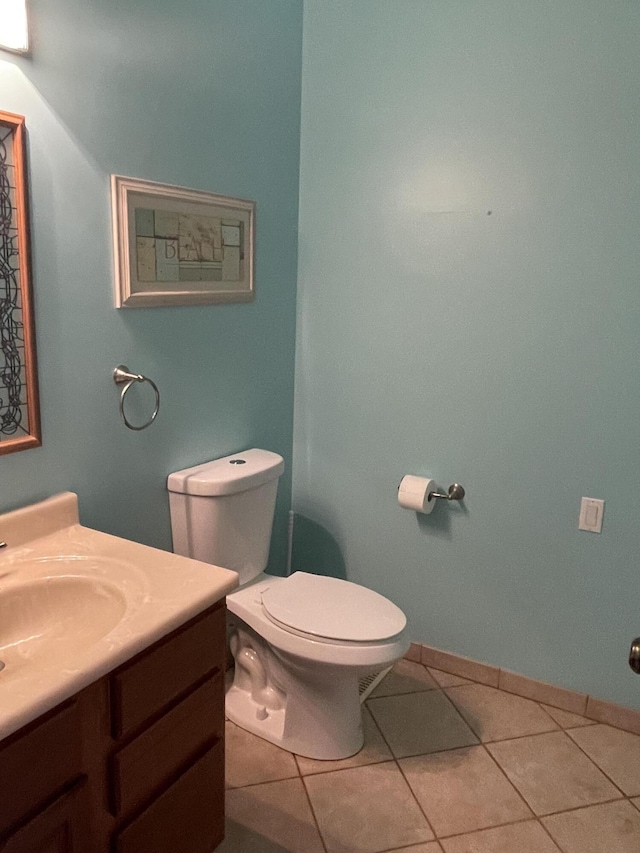 bathroom featuring vanity, toilet, baseboards, and tile patterned flooring