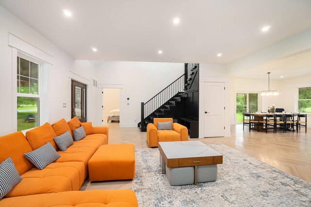 living room featuring light parquet flooring and a notable chandelier