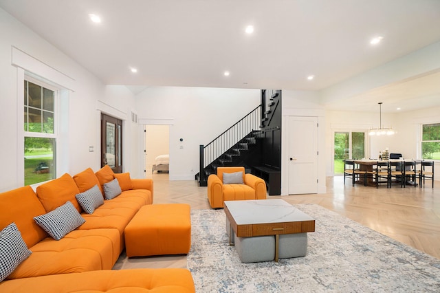 living room with an inviting chandelier and light parquet flooring