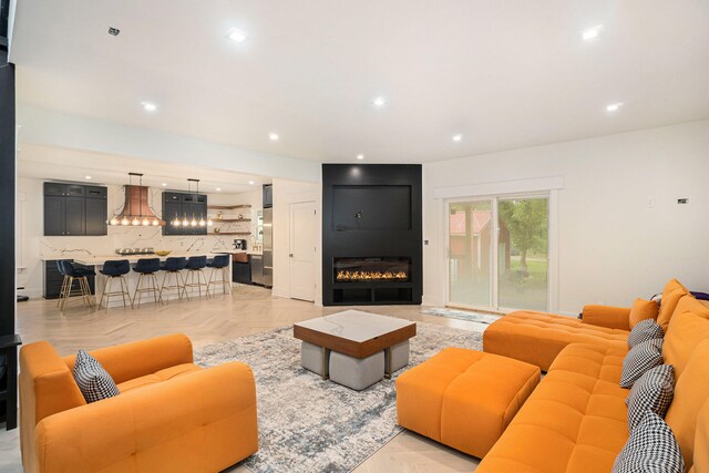 living room with a fireplace and light parquet flooring