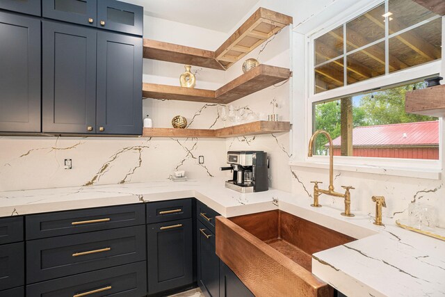 kitchen featuring sink, tasteful backsplash, and light stone countertops