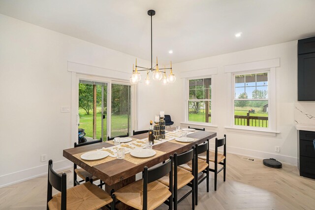 dining room with a wealth of natural light, light parquet flooring, and a chandelier