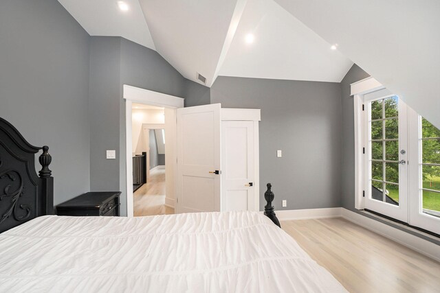 bedroom featuring light hardwood / wood-style floors and lofted ceiling