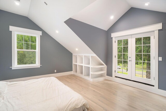 unfurnished bedroom with light wood-type flooring, vaulted ceiling, french doors, and multiple windows