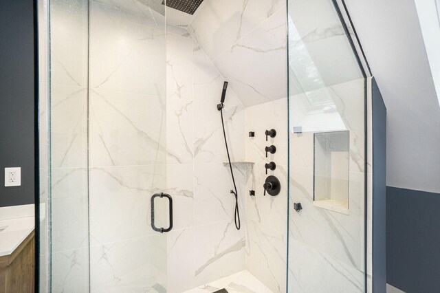 bathroom with a shower with door and vanity