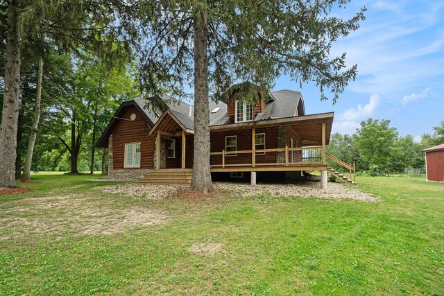 back of property with a wooden deck and a lawn