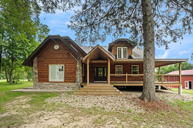 log-style house with a wooden deck and french doors