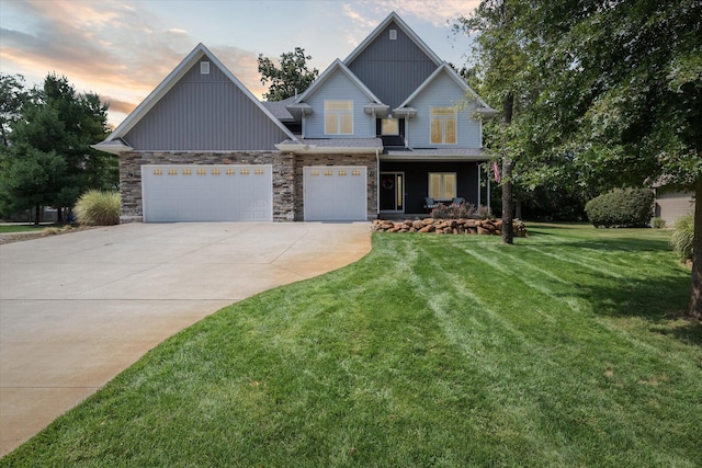 craftsman inspired home with a front lawn, stone siding, covered porch, concrete driveway, and a garage