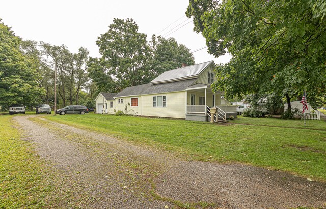 view of side of home with a lawn and covered porch