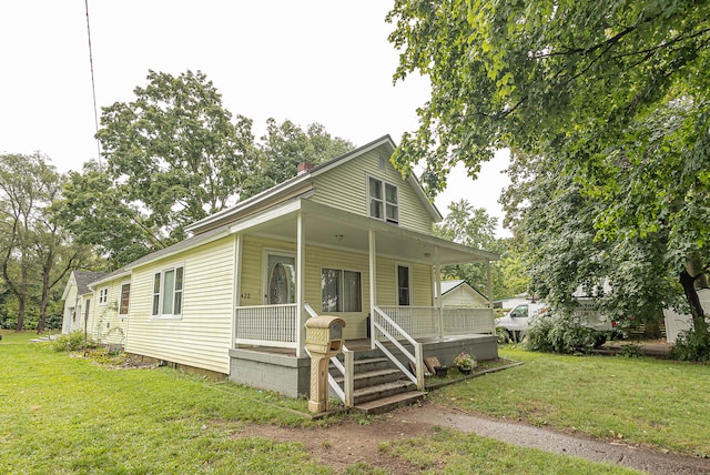 view of front of house with a porch and a front yard