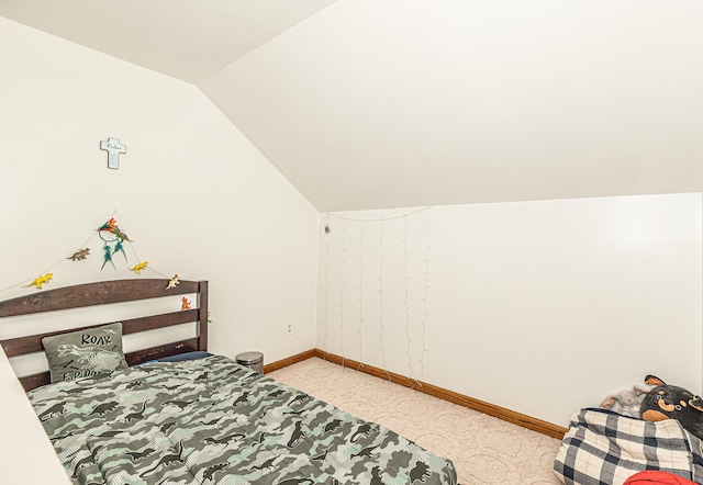 bedroom with vaulted ceiling and light carpet