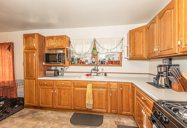 kitchen with sink, range, and light tile patterned floors