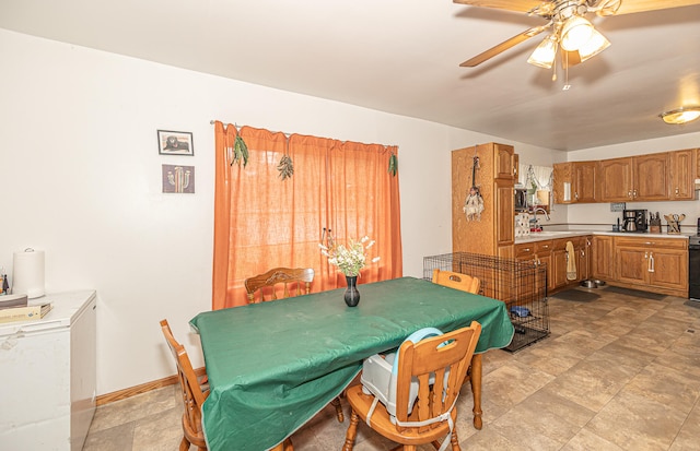 tiled dining area with ceiling fan and sink