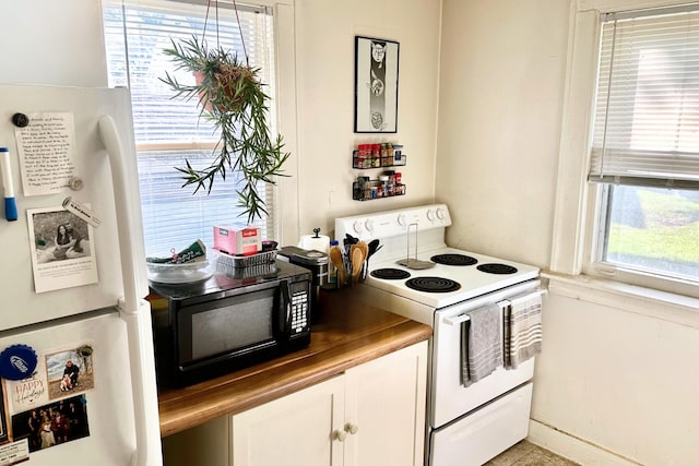 kitchen featuring white cabinetry and white appliances