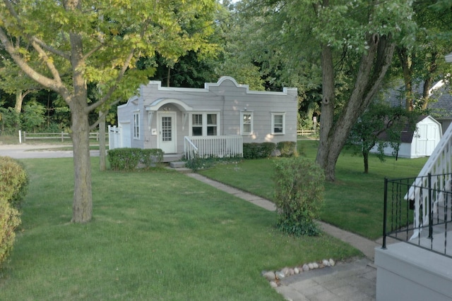 view of front of house with a front lawn and a storage unit