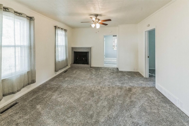 unfurnished living room with carpet flooring, ceiling fan, and a healthy amount of sunlight