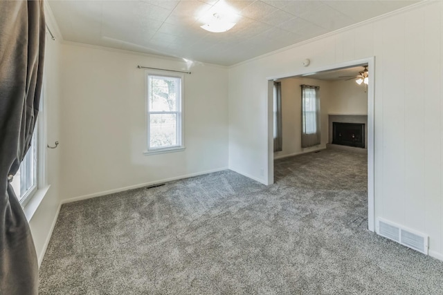 carpeted spare room with ceiling fan and crown molding