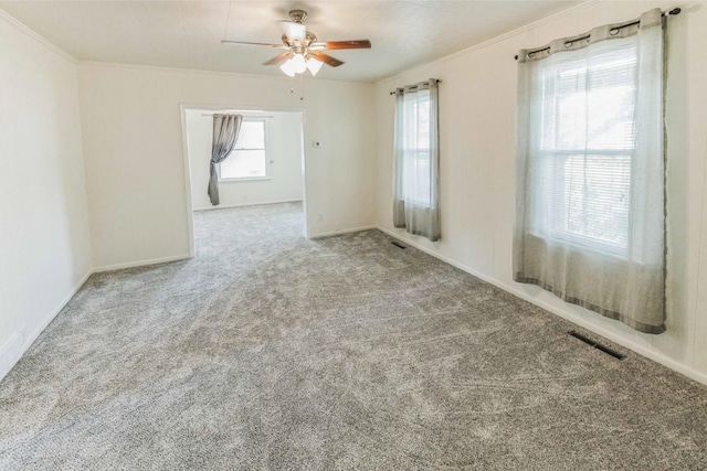 carpeted empty room featuring ceiling fan and crown molding