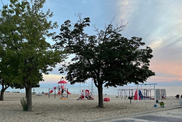 playground at dusk featuring a water view