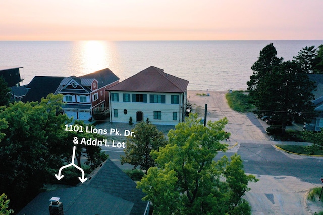 aerial view at dusk featuring a water view