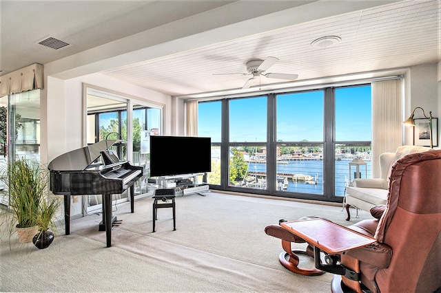 living area featuring carpet flooring and ceiling fan