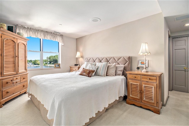 bedroom with visible vents and light carpet