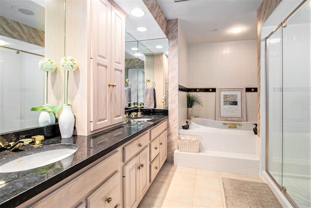 full bath with double vanity, a stall shower, a sink, tile patterned floors, and a bath